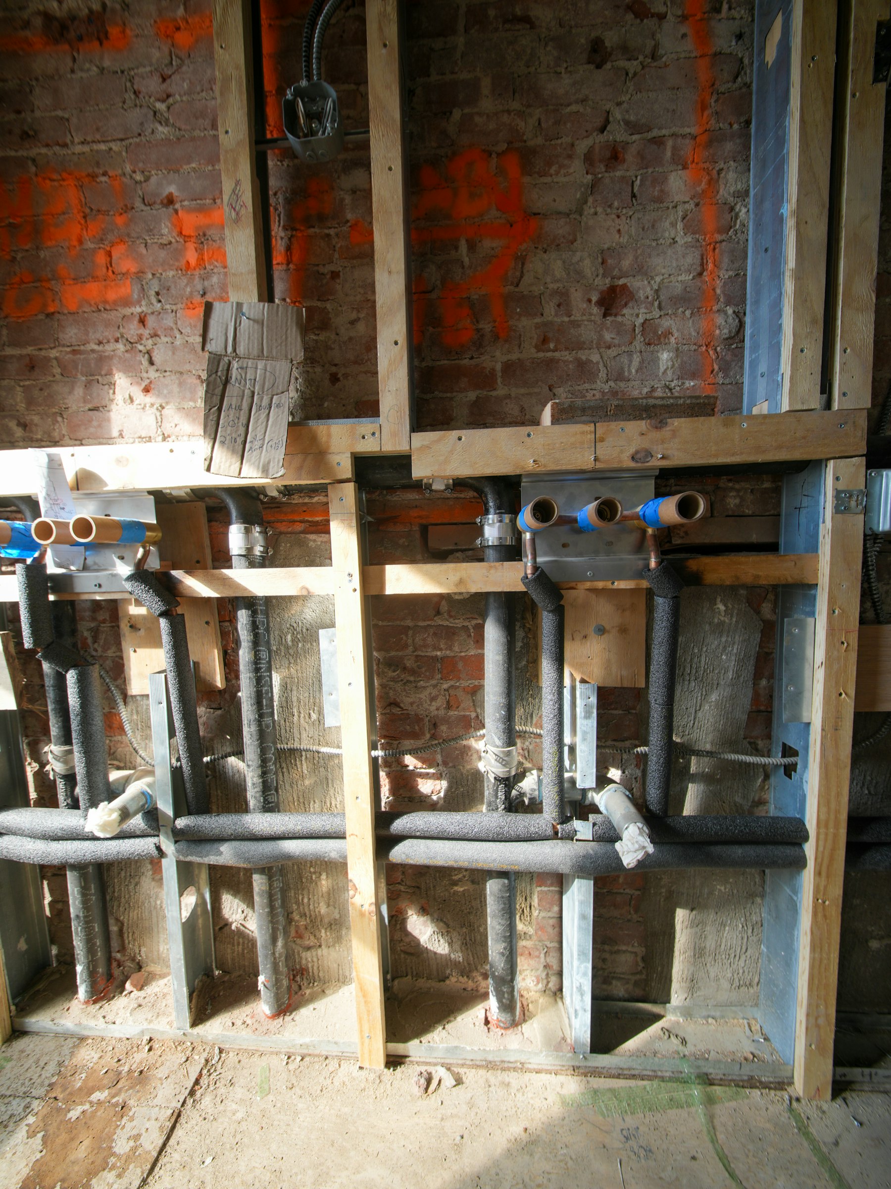 Exposed plumbing pipes inside a wall